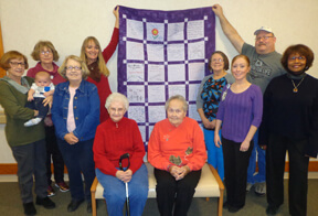 women holding cancer quilt